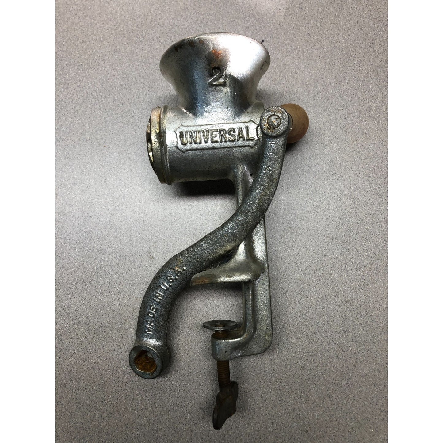 Vintage metal meat grinder with 'Universal' branding on a gray background