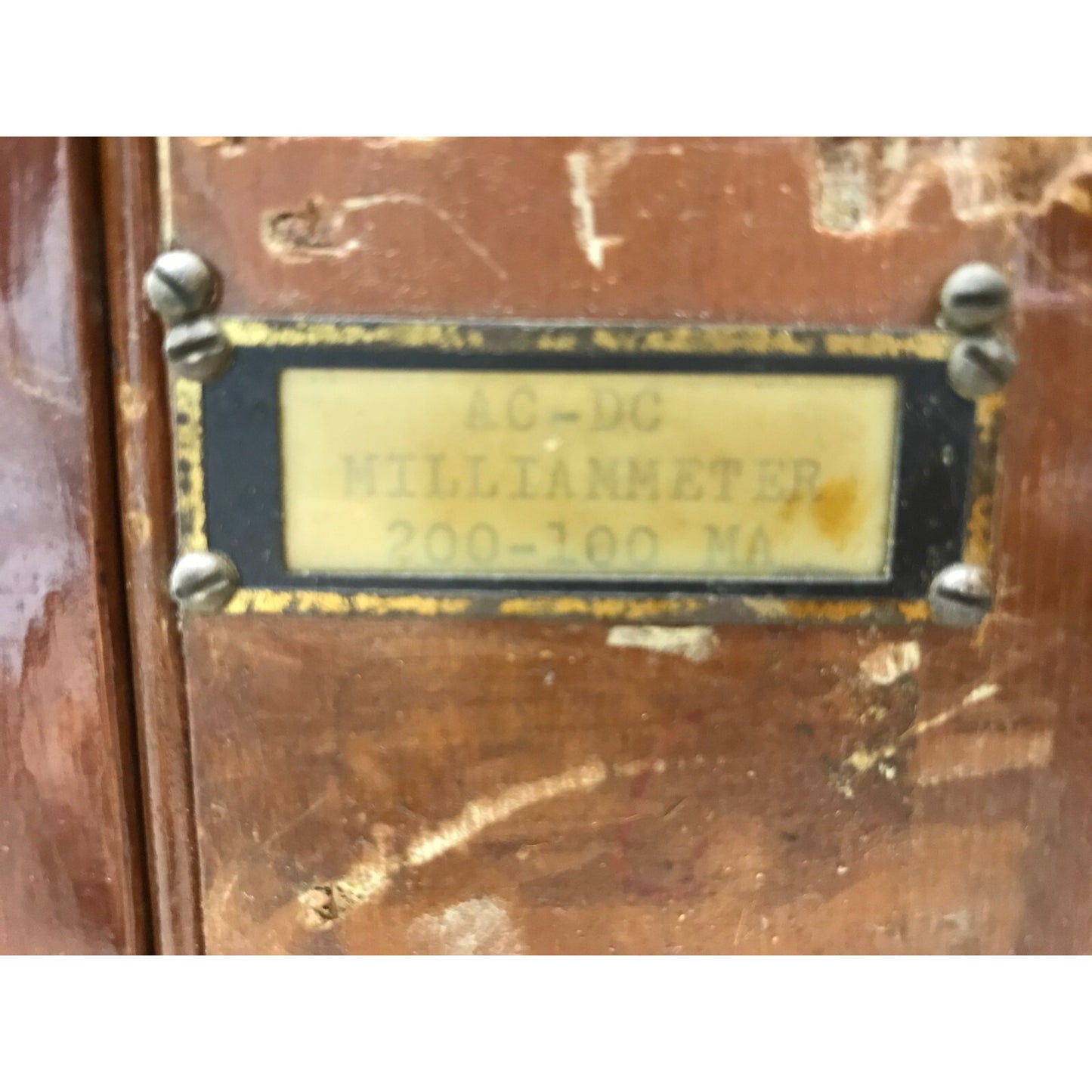 Vintage meter with a label on a wooden surface
