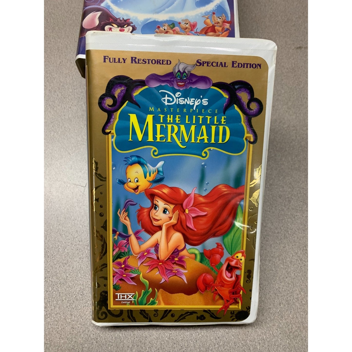 VHS tape of 'The Little Mermaid' with animated characters on a beige background