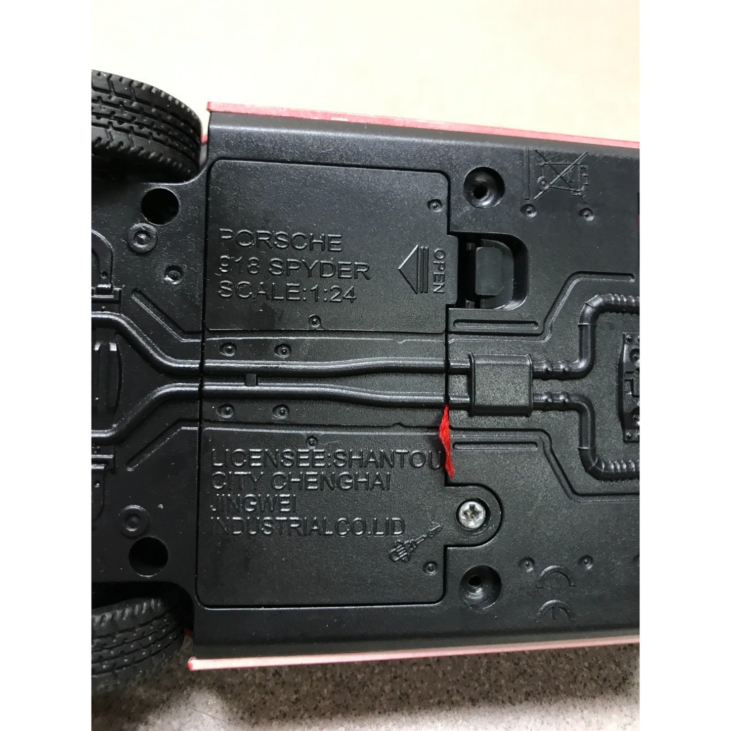 Close-up of a toy car's bottom with branding and specifications.