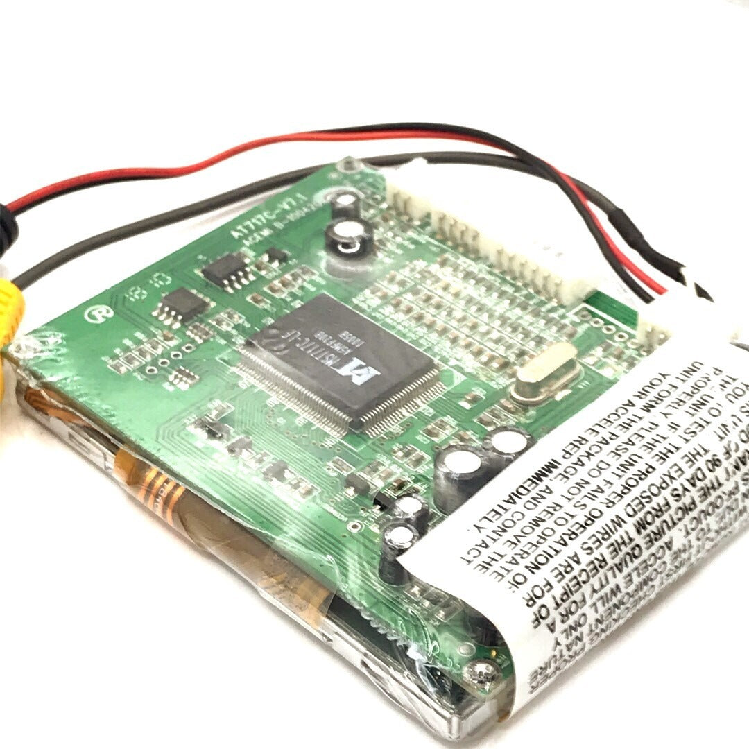 Close-up of a green electronic circuit board with components and wires on a white background