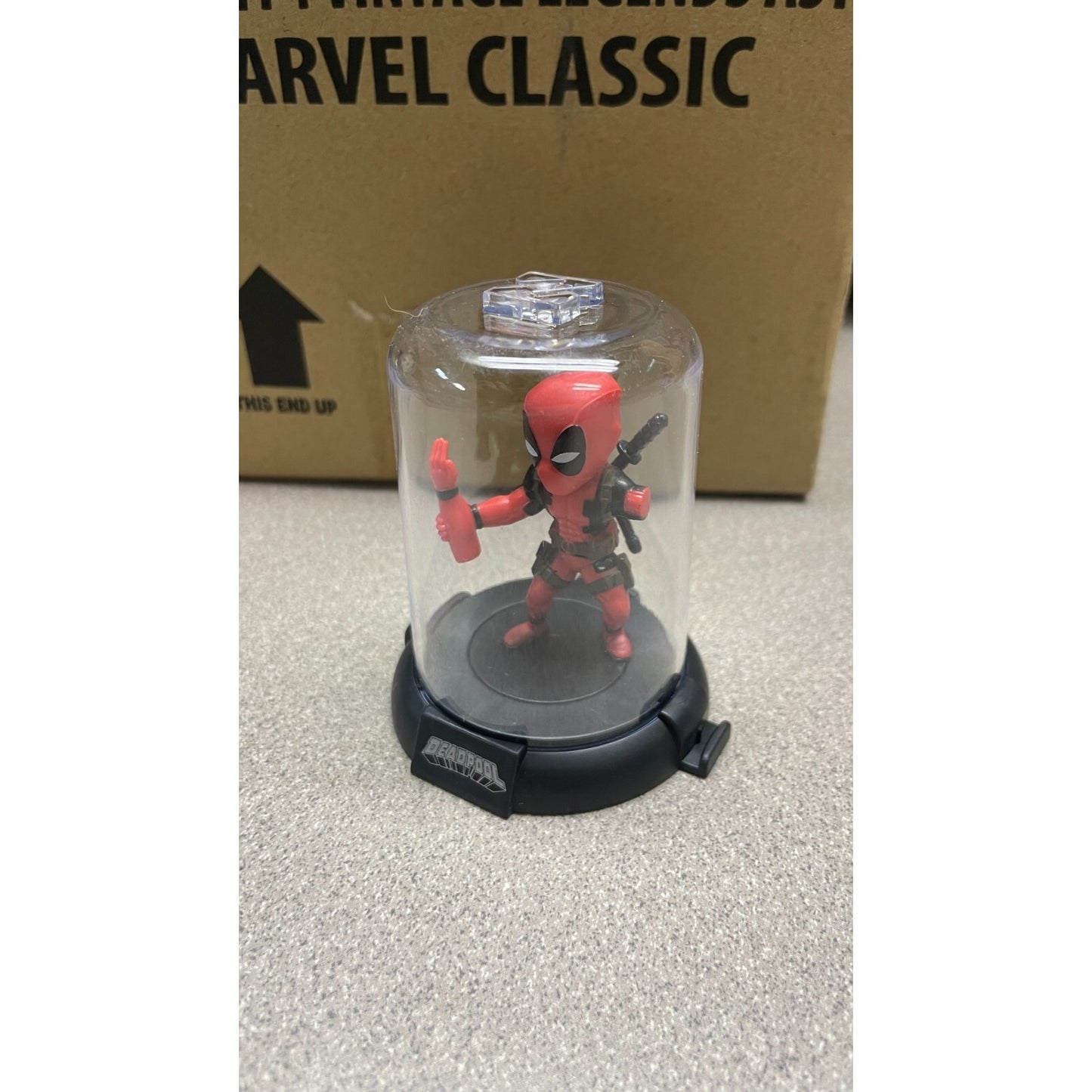 Domez Deadpool Collectible 2 of 8 (Missing Arm Pose) side view in display case