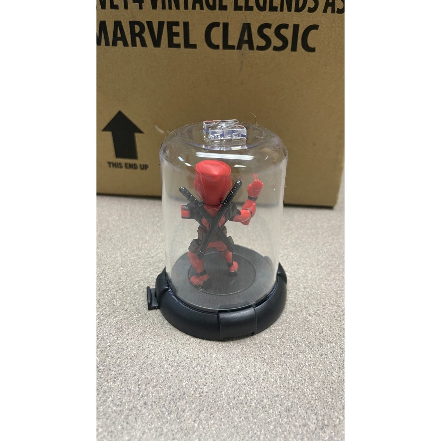 Domez Deadpool Collectible 2 of 8 (Missing Arm Pose) back view in display case