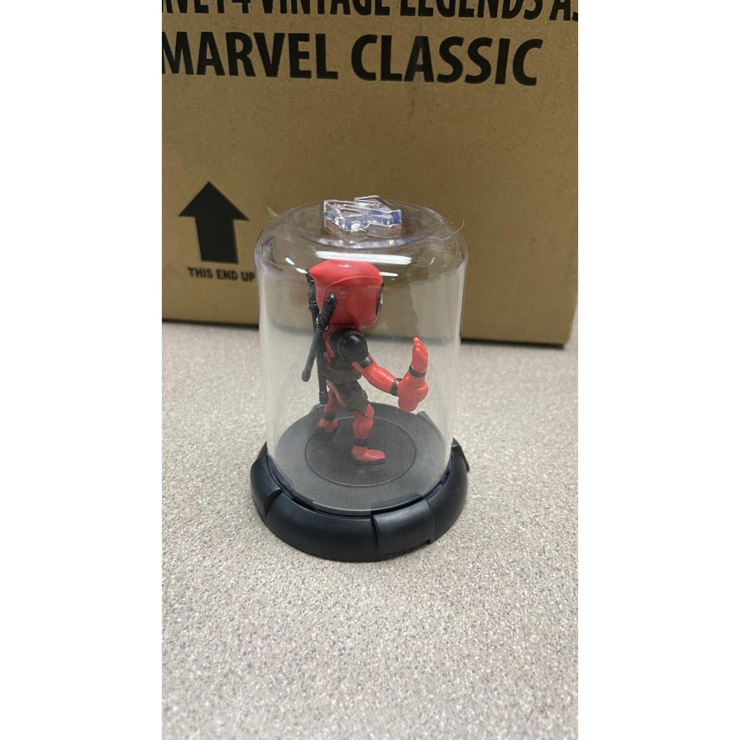 Domez Deadpool Collectible 2 of 8 (Missing Arm Pose) back/side view in display case