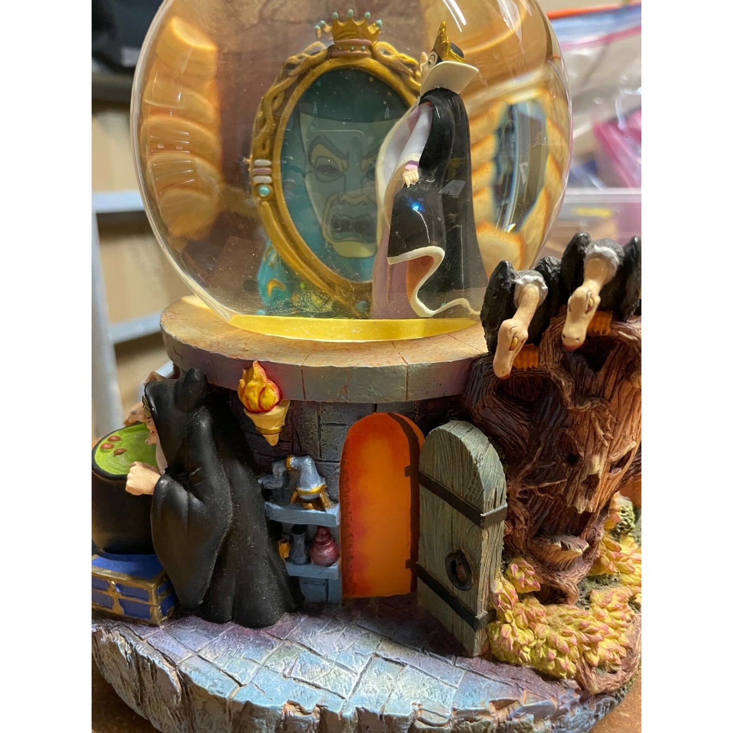 Decorative scene with characters and a mirror inside a glass dome