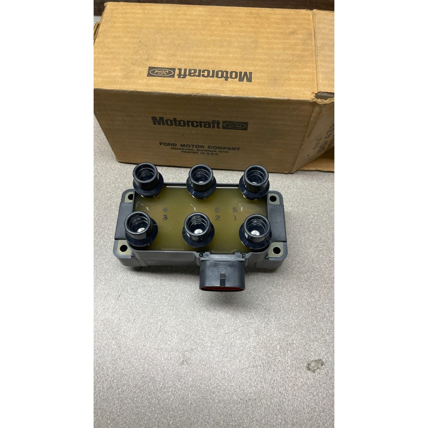 Motorcraft FORD 12 Volt Ignition Coil, part E9DF-12029-AA, 029700-6770 Car ignition switch housing with Motorcraft box in the background