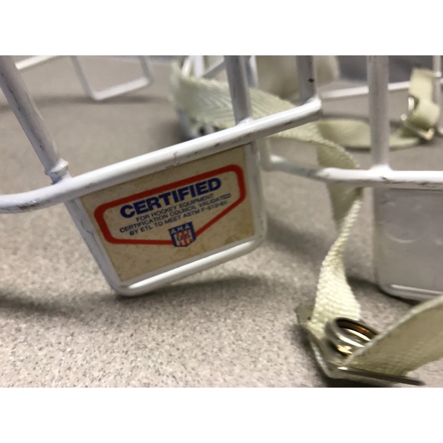 Two Hockey Cage Masks White Metal 7.5 inch (one with chin pad) Certified label closeup