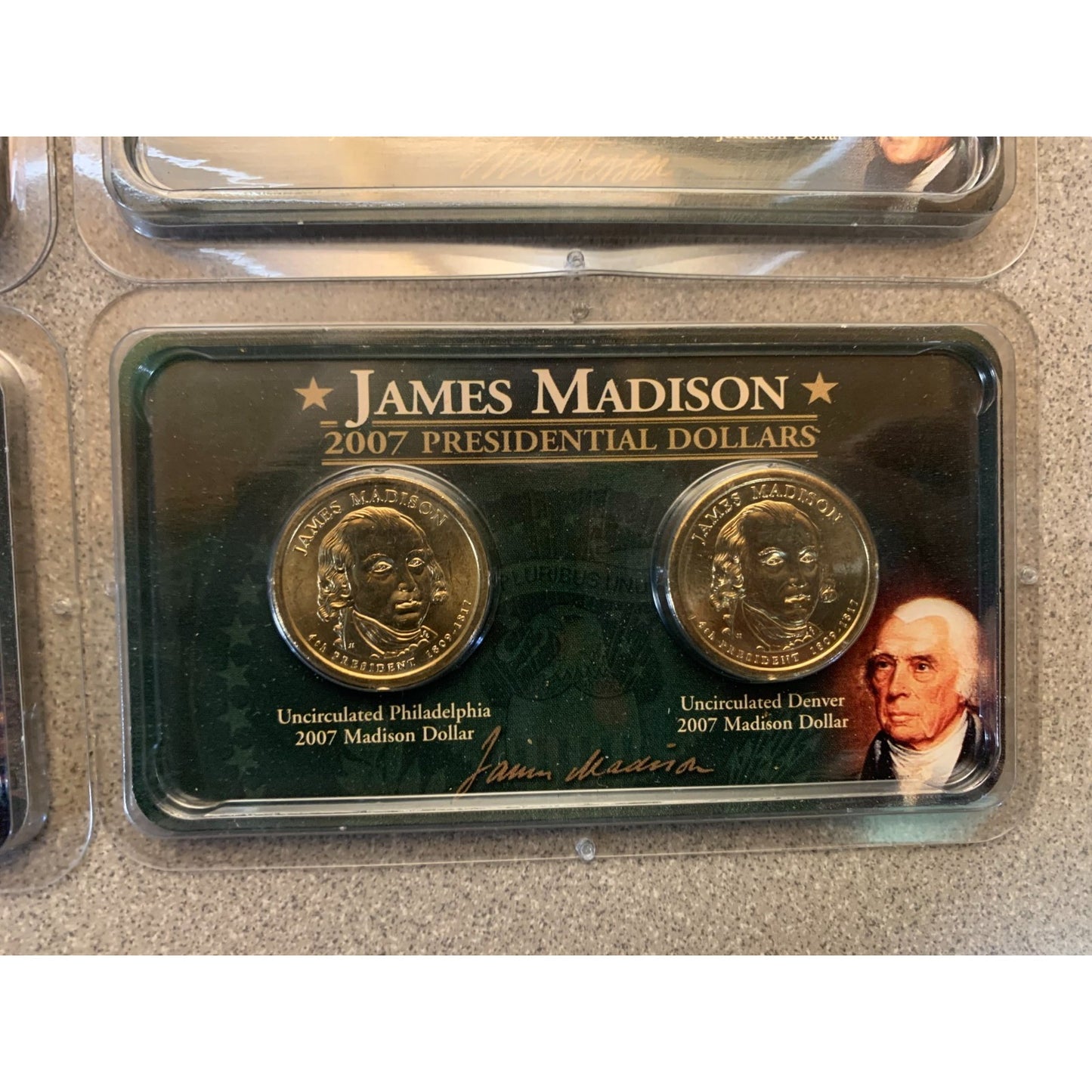 Two gold coins in a display case with 'James Madison' branding.