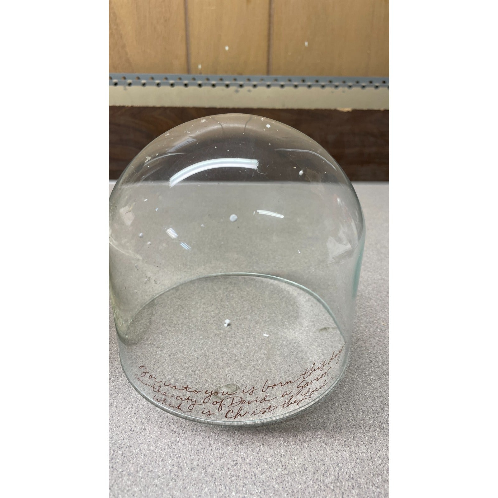 Clear glass dome with engraved text on a reflective surface