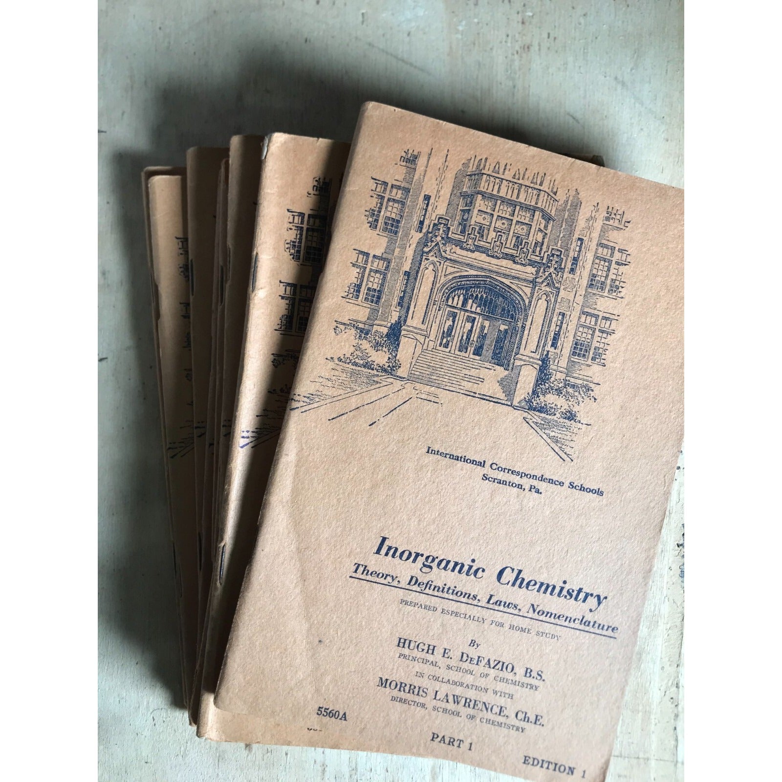 Vintage book titled 'Inorganic Chemistry' with architectural illustration on a textured surface