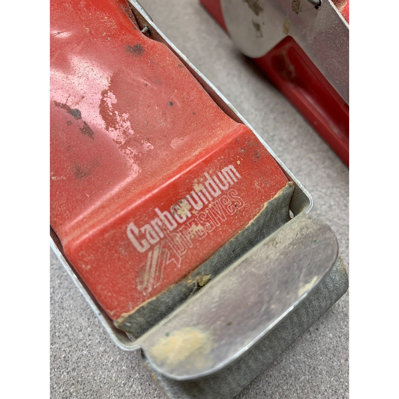 Red Carborundum sanding block closeup of logo