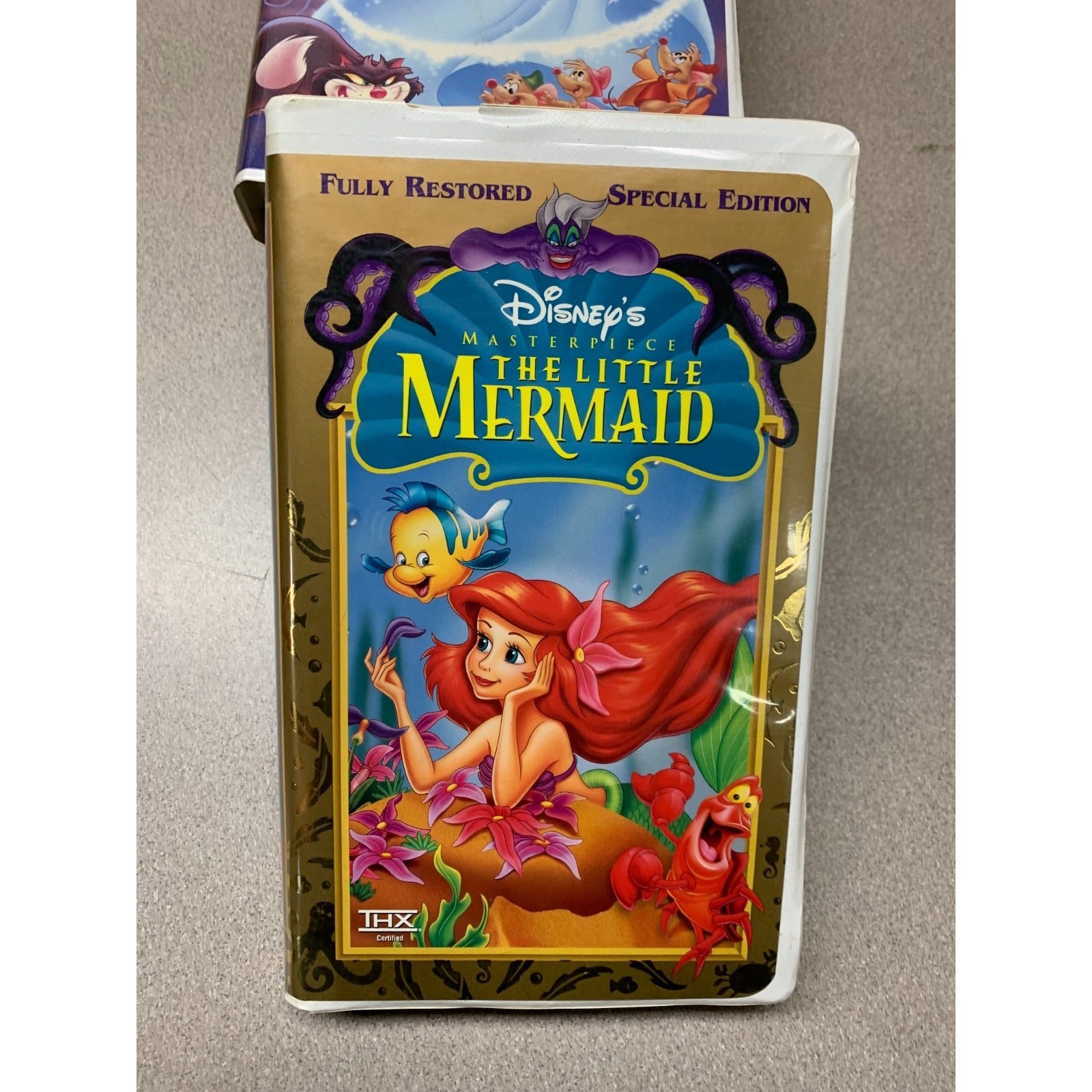 VHS tape of 'The Little Mermaid' with animated characters on a beige background