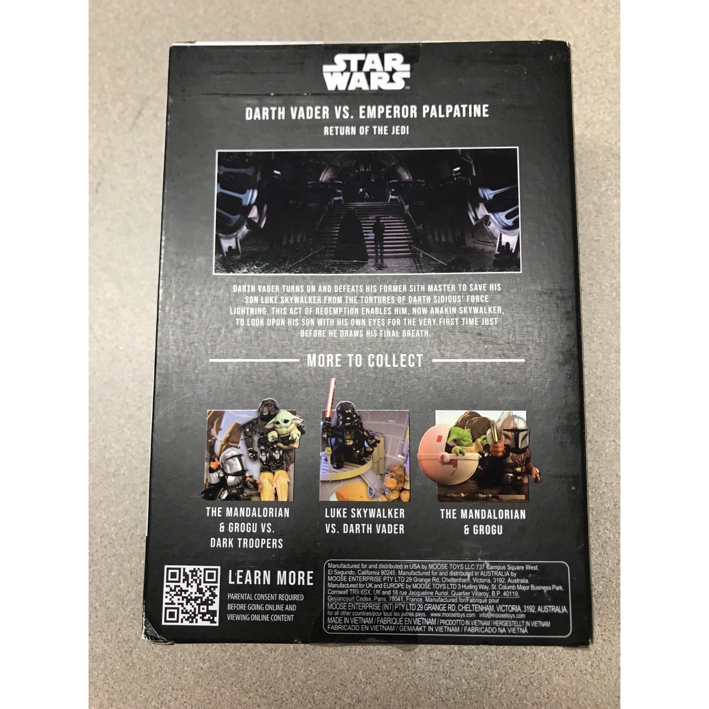 The back cover of a Star Wars Darth Vader vs. Emperor Palpatine collectible figure box, featuring character images and release notes on a black background, photographed on a beige carpet.