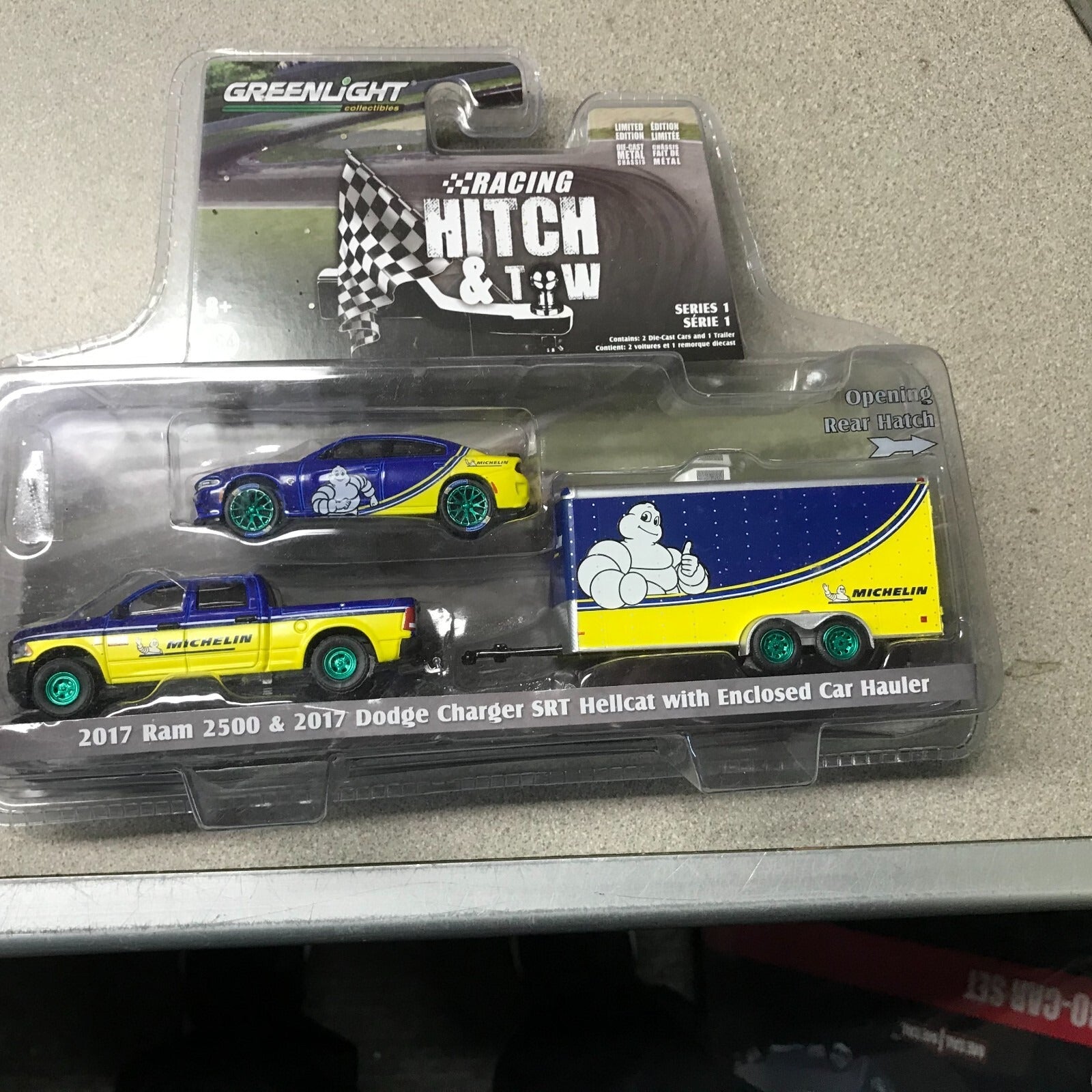 Greenlight Racing Hitch and Tow 2017 Ram 2500 &amp; Dodge Charger SRT Hellcat with Enclosed Car Hauler front of package displaying car and truck