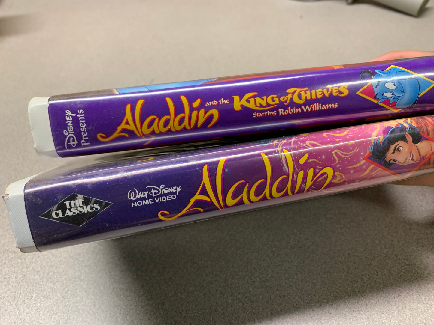 Aladdin Rare Black Diamond Ed. and Aladdin and the King of Thieves Disney VHS tapes spine of tape cases displaying video names