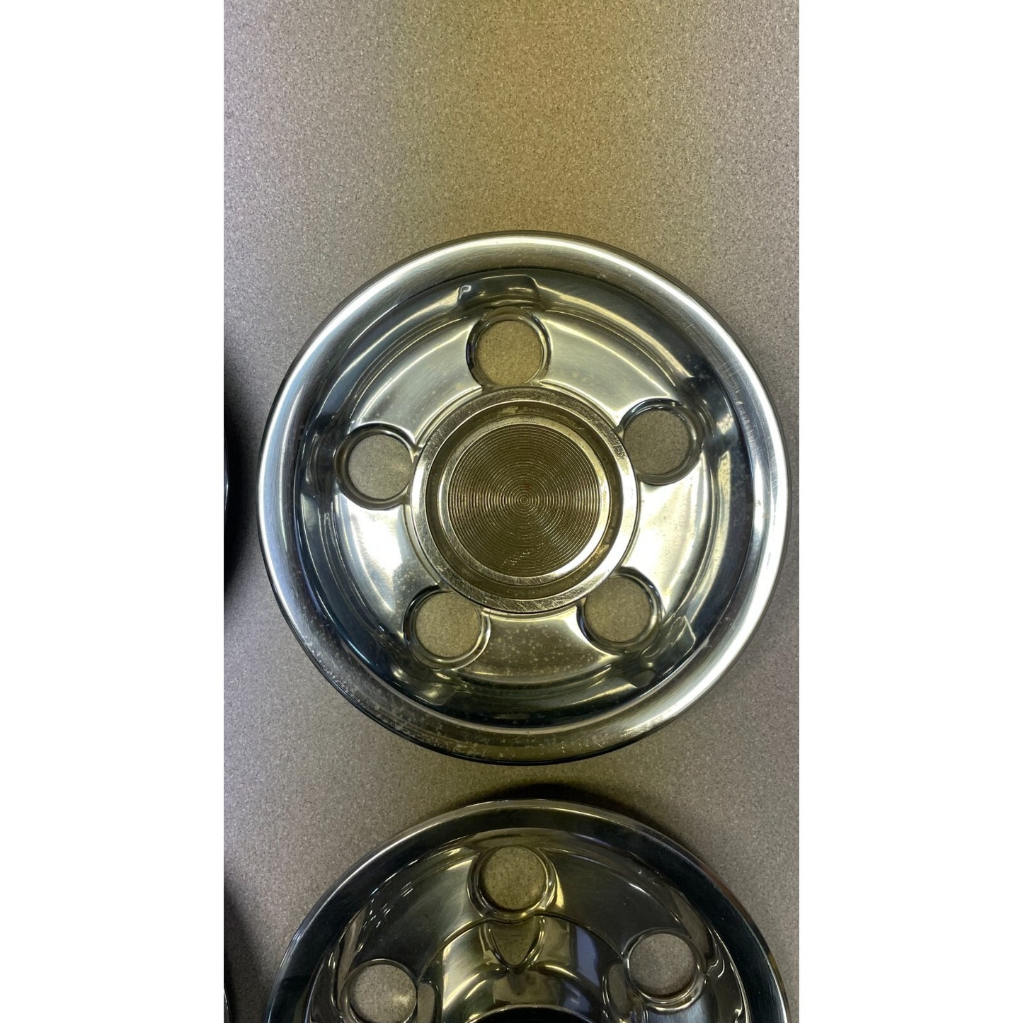 Close-up of a metallic hubcap on a gray background