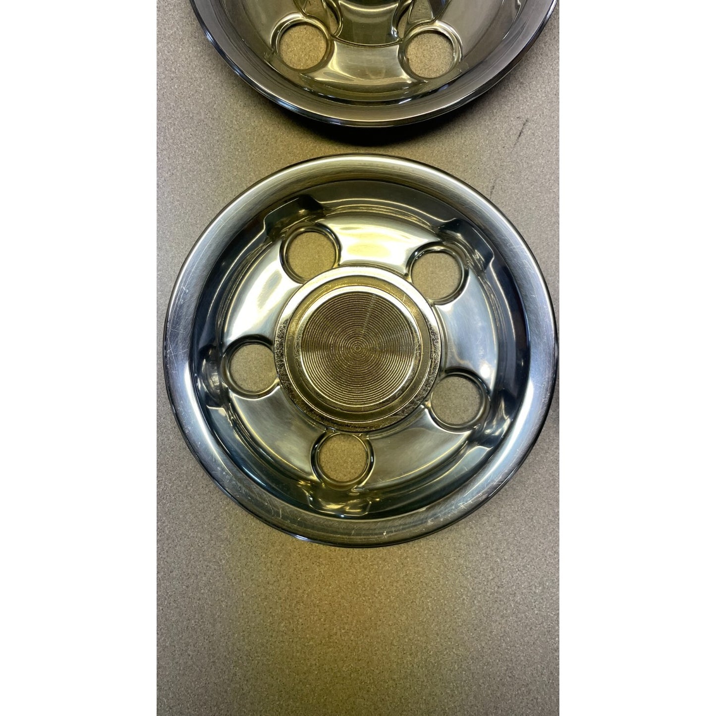 Two metallic bowl bases on a beige surface