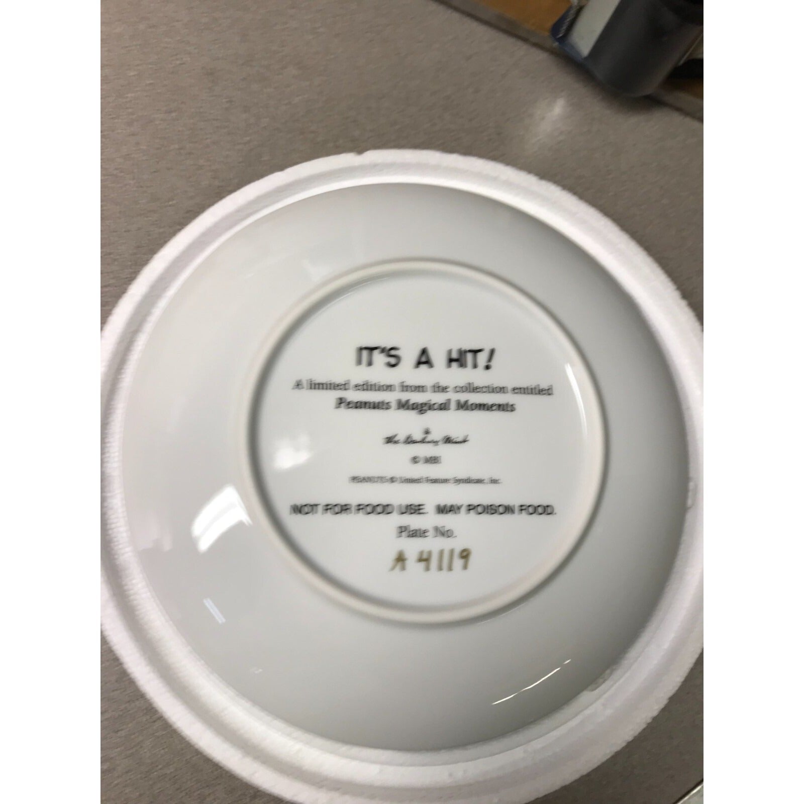 The Danbury Mint Peanuts Magical Moments Plates  "It's a Hit!" Serial No. A4119 back of plate