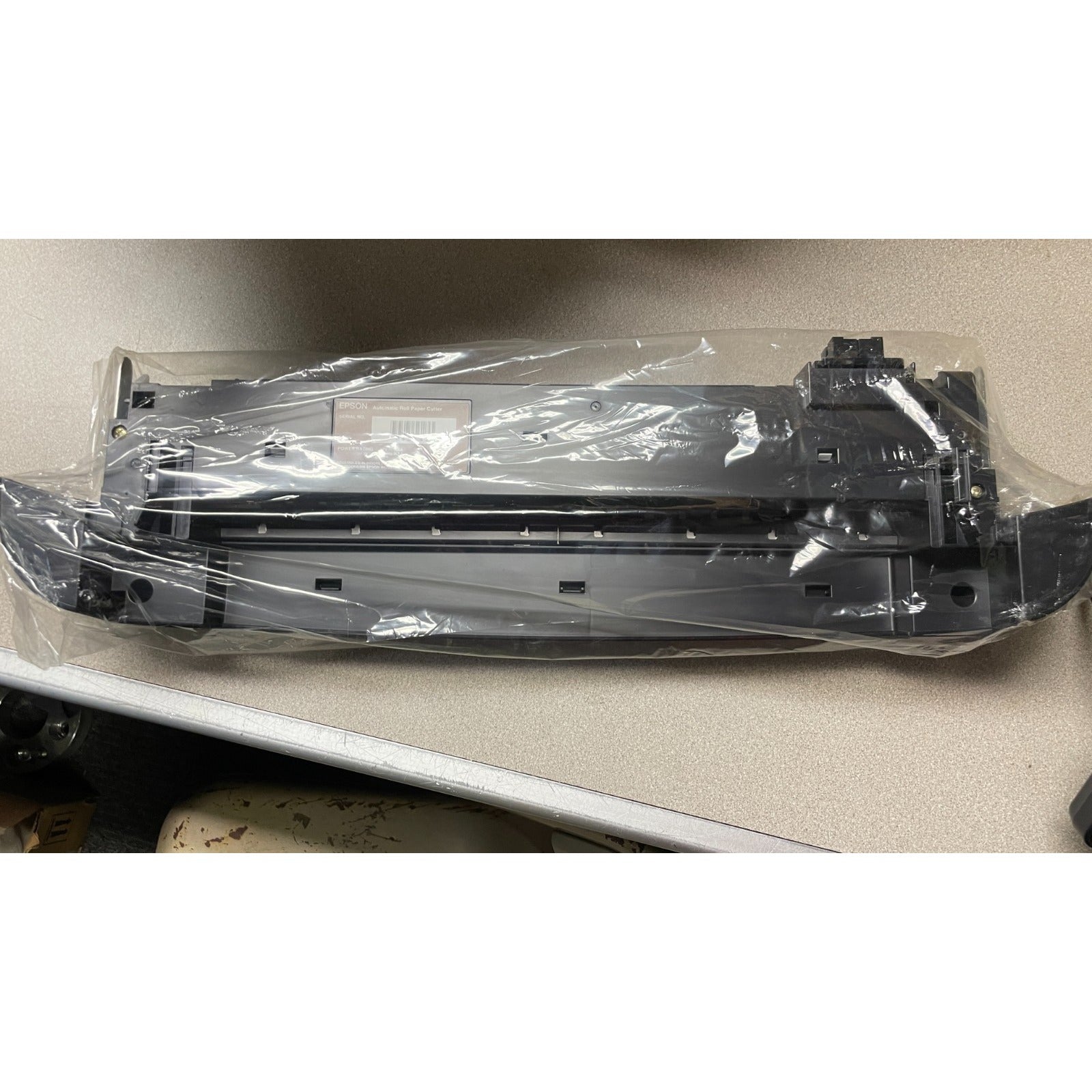 Epson Automatic Roll Paper Cutter underside view in plastic packaging