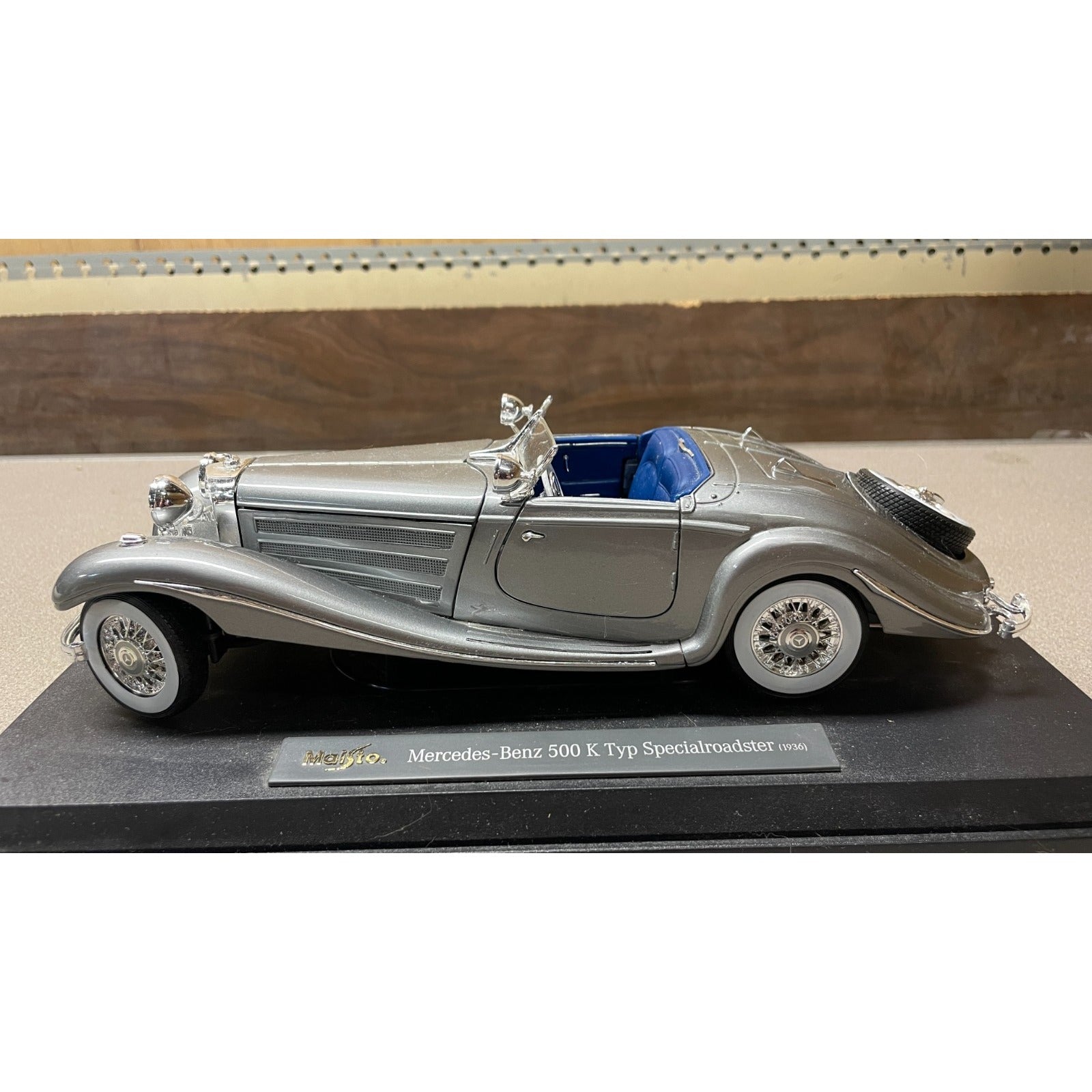 Maisto Silver 1936 Mercedes-Benz 500 K Typ Specialroadster 1:18 Scale Diecast Model drivers side view on display platform