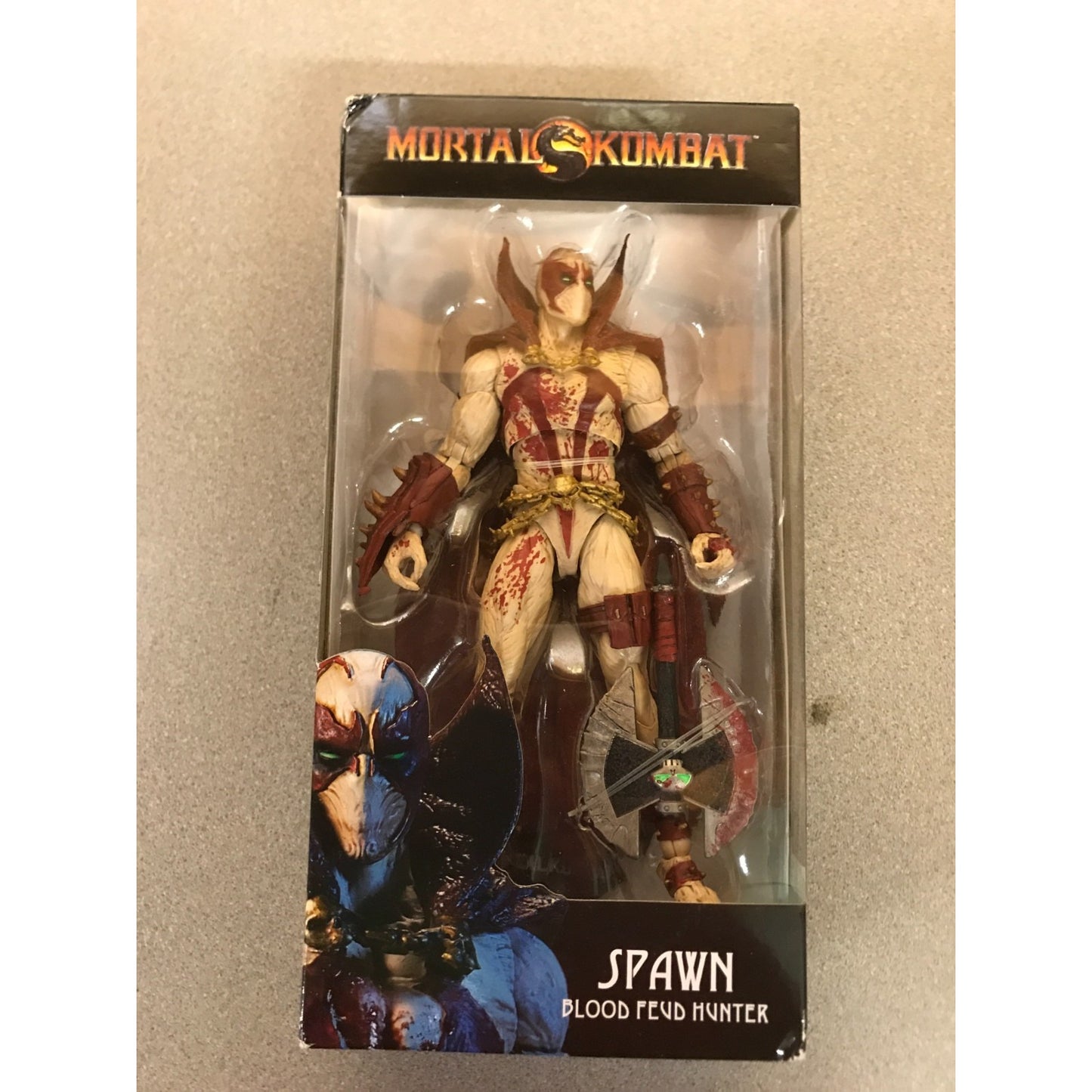 Mortal Kombat Spawn Blood Feud Hunter action figure in its original window box packaging, featuring Spawn with a bow and axe on a beige background.