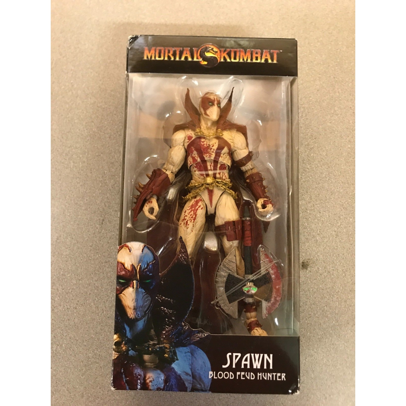 Mortal Kombat Spawn Blood Feud Hunter action figure in its original window box packaging, featuring Spawn with a bow and axe on a beige background.