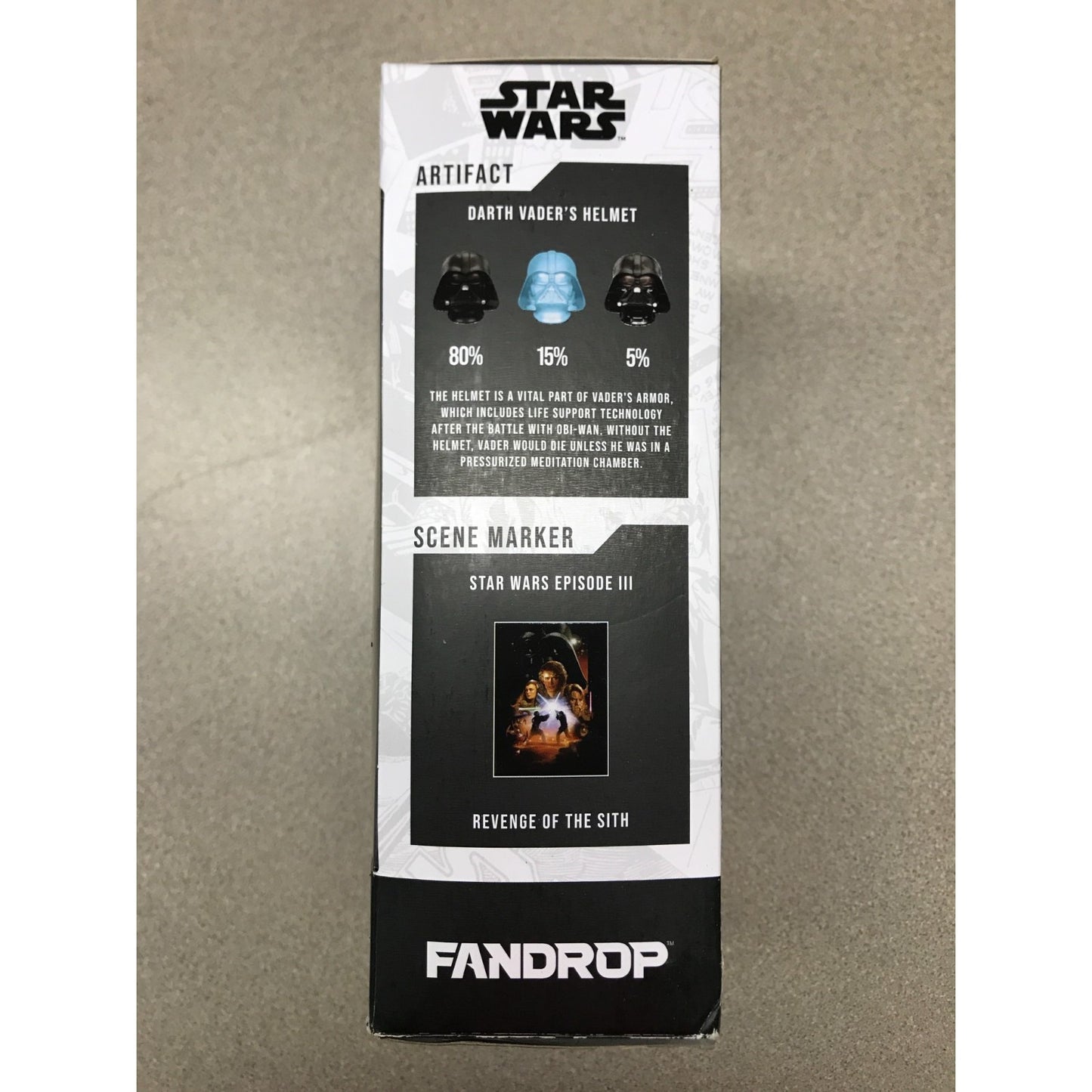 A Fandrop Star Wars Artifact and Scene Marker display box, featuring Darth Vader's Helmet and Revenge of the Sith Scene Marker, photographed on a neutral gray surface.