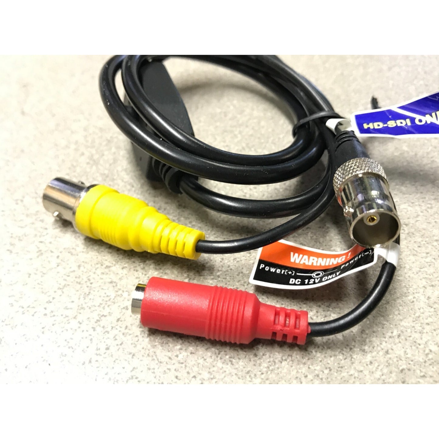 Cable with yellow, red, and silver connectors on a beige surface