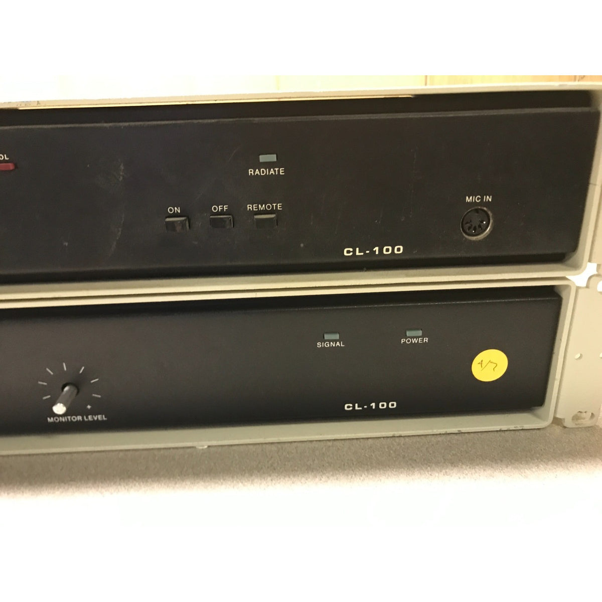 A vintage CL-100 audio amplifier or receiver module with a black front panel, beige side casing, and a yellow power button on the lower section.