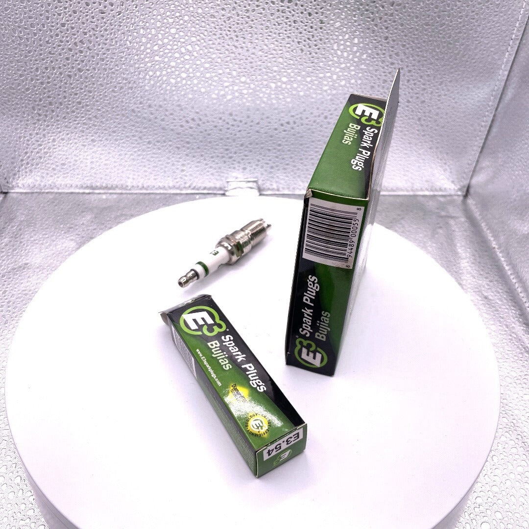 Two boxes of E3 Spark Plugs on a white plate with a silver background