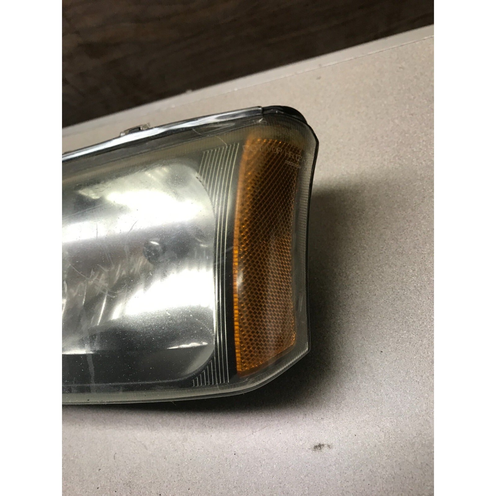 GM 16530938 Left Top Headlight Lens, Fits 2003 Chevy Silverado 2500HD directional closeup