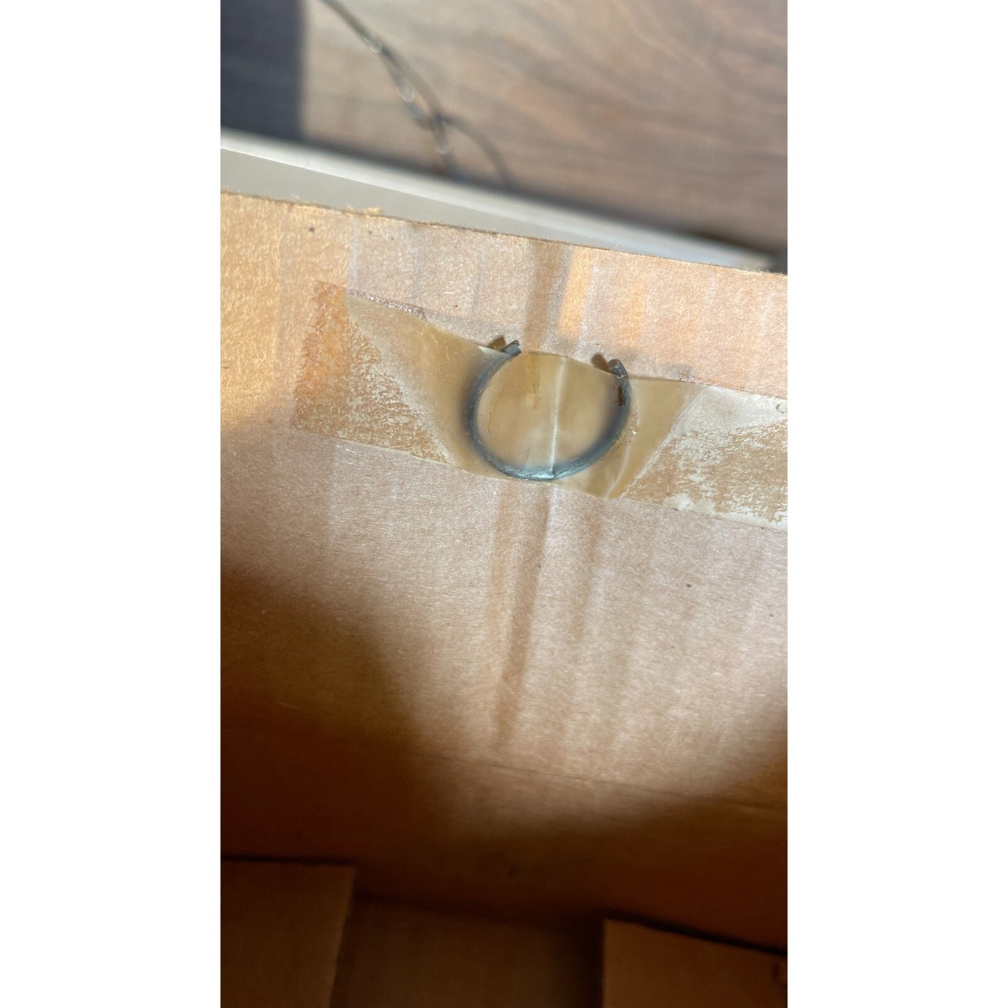 Clear plastic ring on a wooden surface with a white background