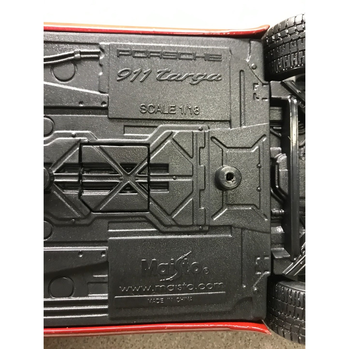 Close-up of a model car with 'Porsche 911 Targa' branding and 'Moisto' label.