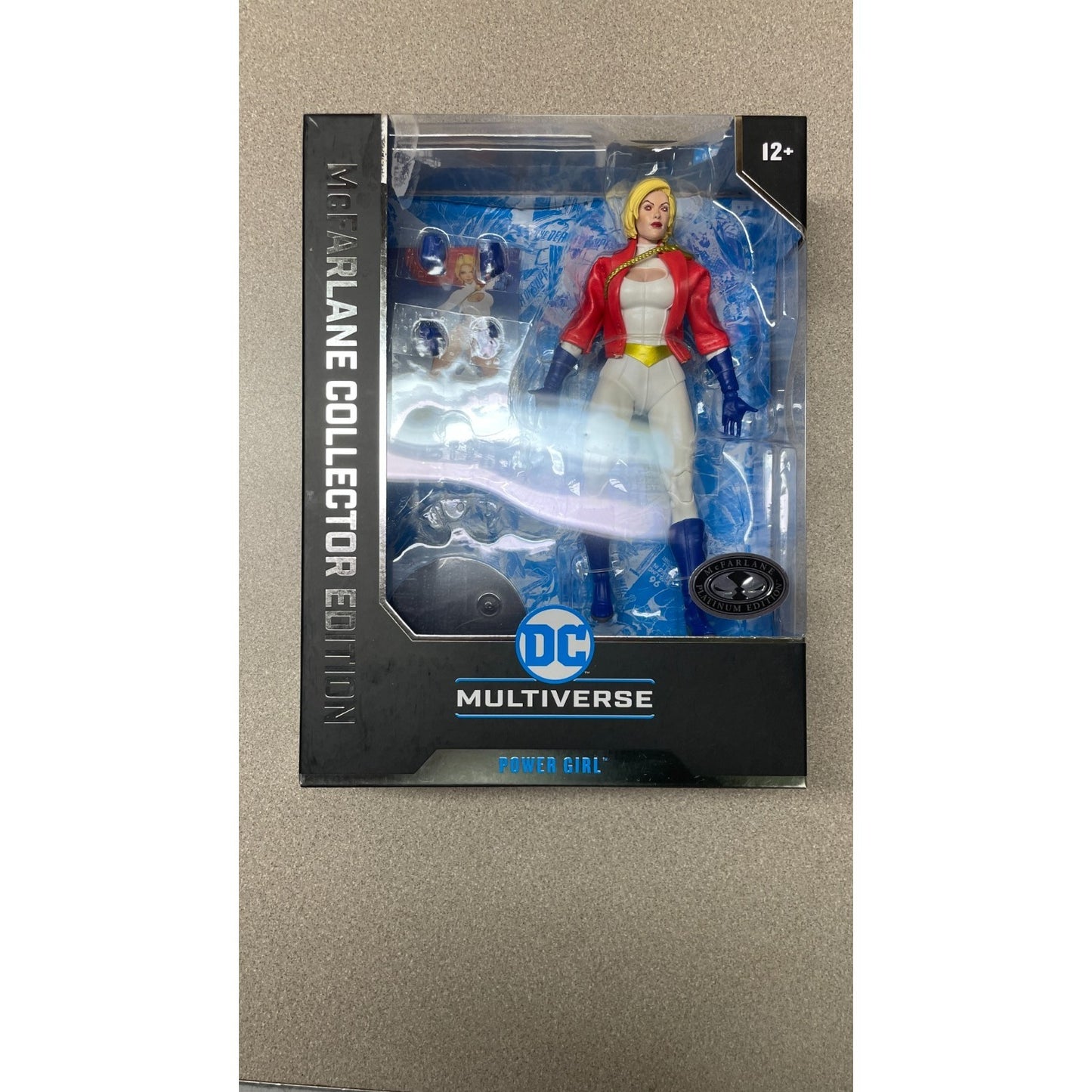 DC Multiverse Power Girl #31 McFarlane Collector Edition front view of package action figure and accessories visible through glare