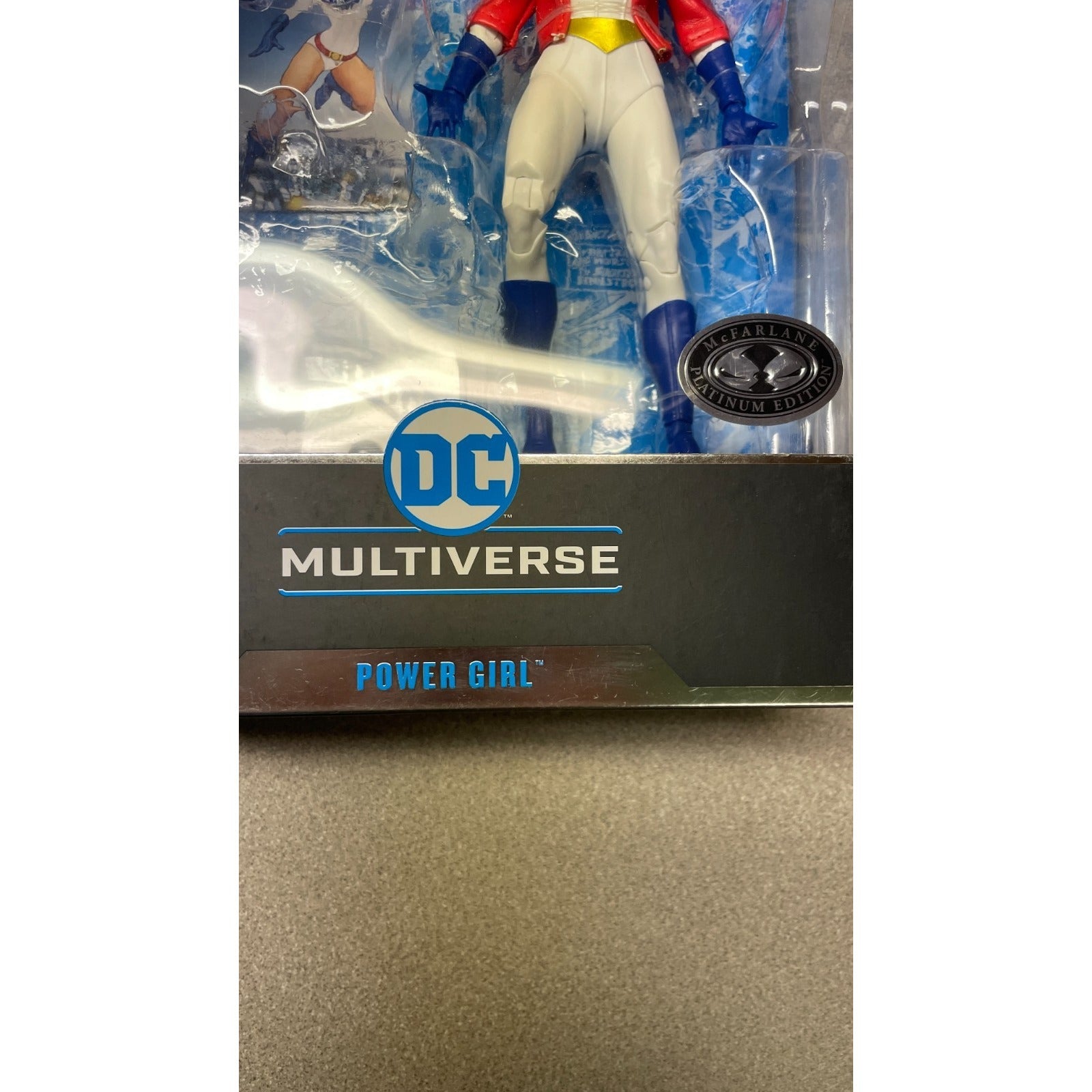 DC Multiverse Power Girl action figure in packaging on a reflective surface