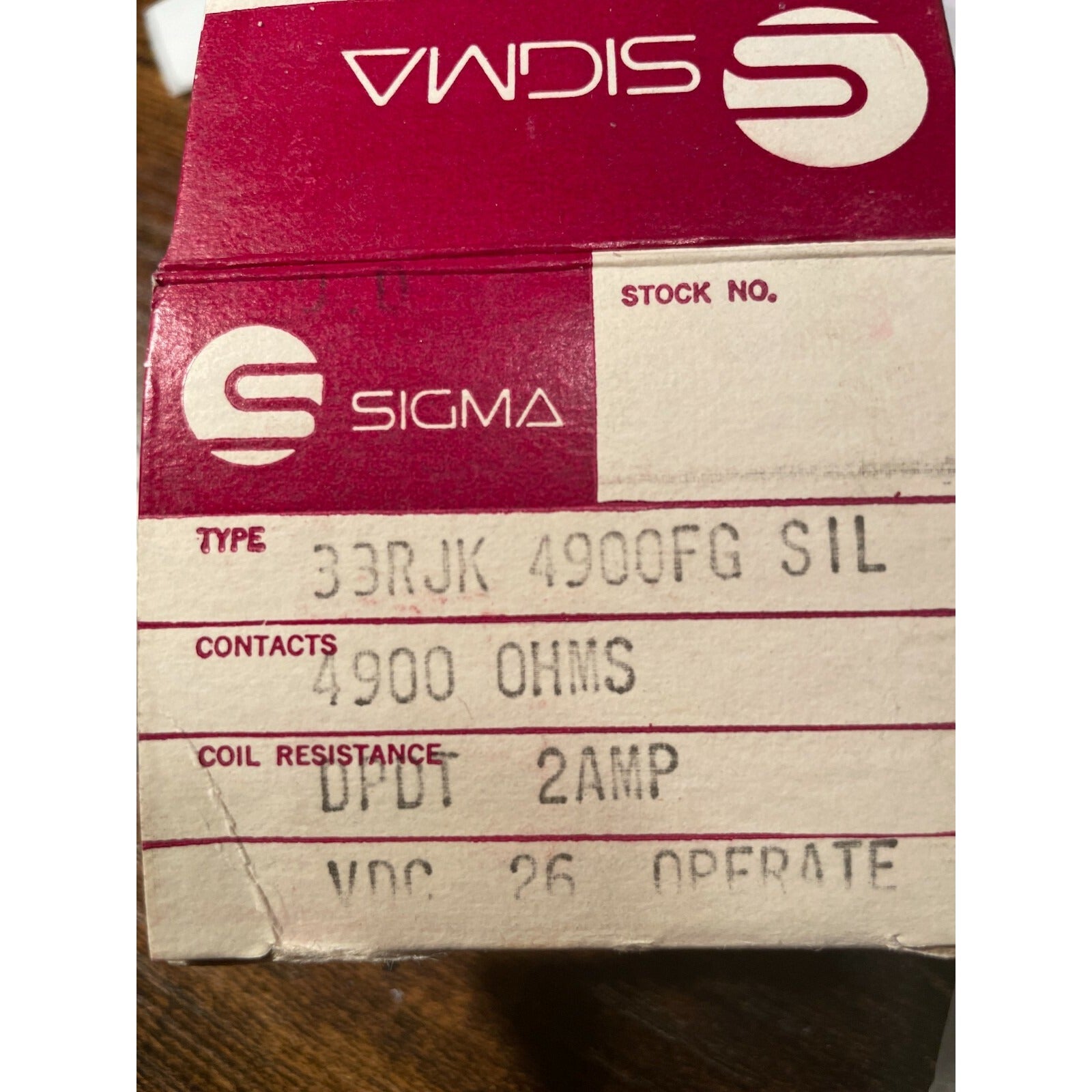 Sigma electrical component box with text on a wooden surface