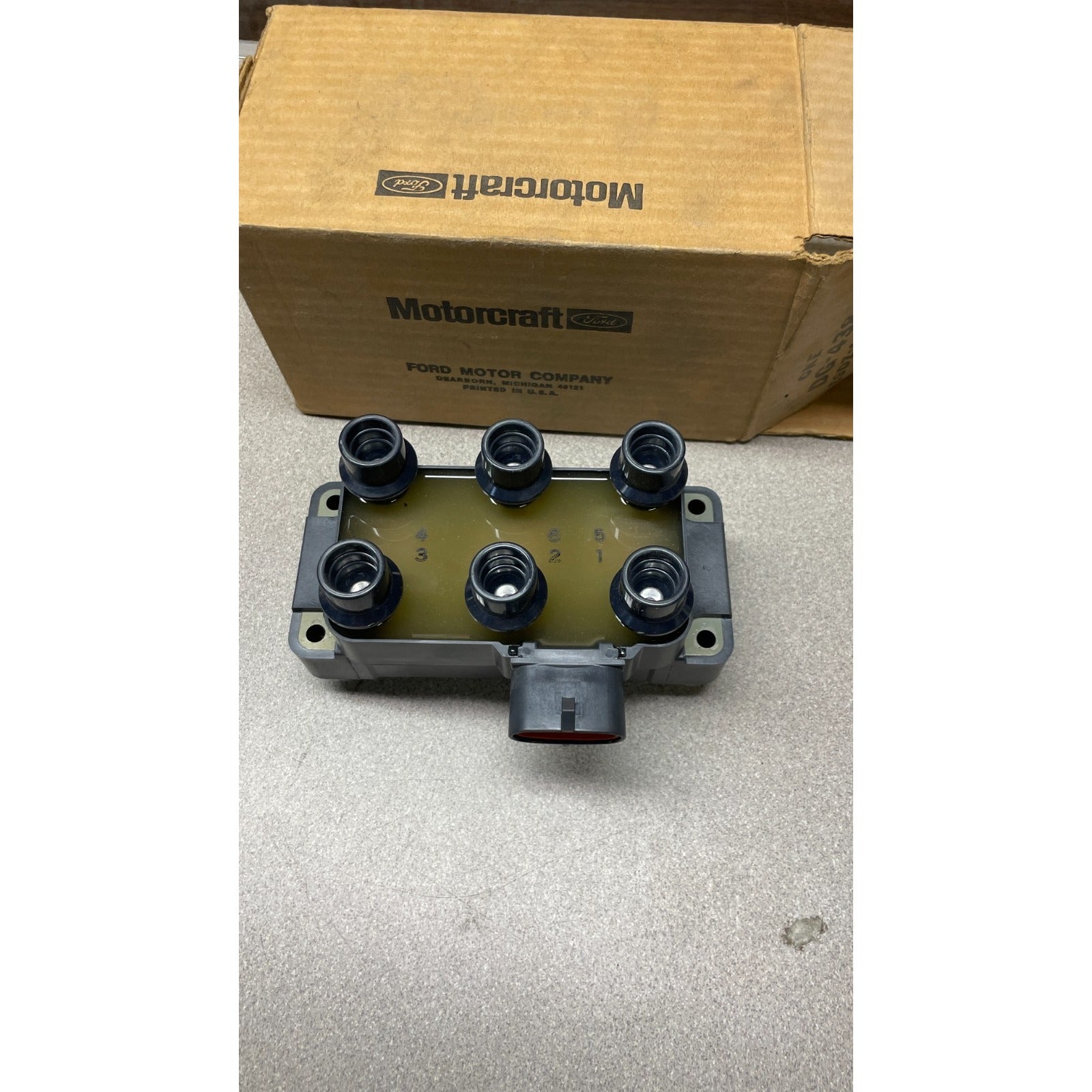Motorcraft FORD 12 Volt Ignition Coil, part E9DF-12029-AA, 029700-6770 Car ignition switch housing with Motorcraft box in the background