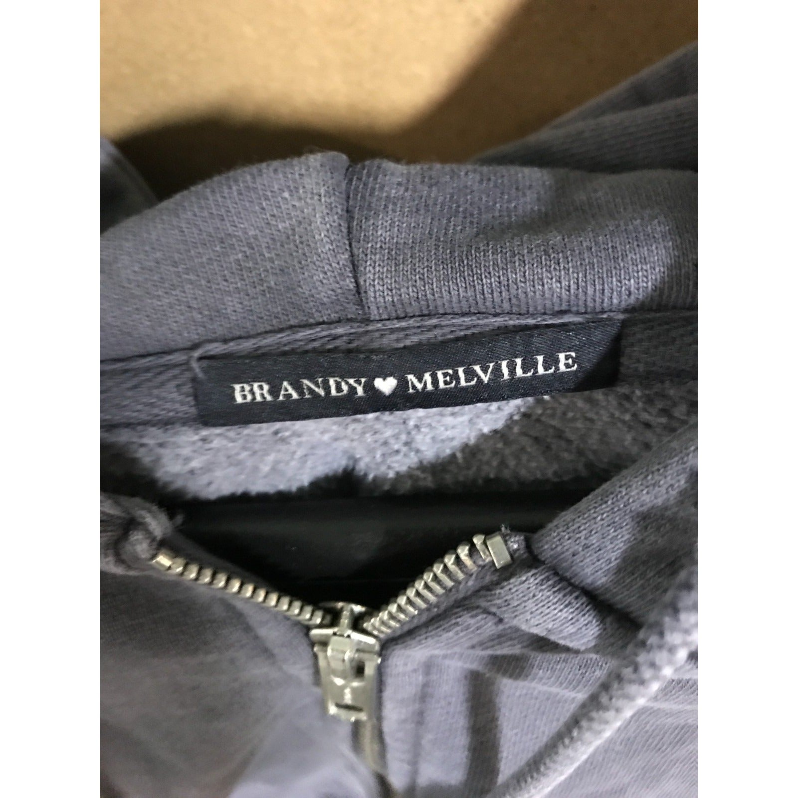 Gray garment with a Brandy Melville label on a white background