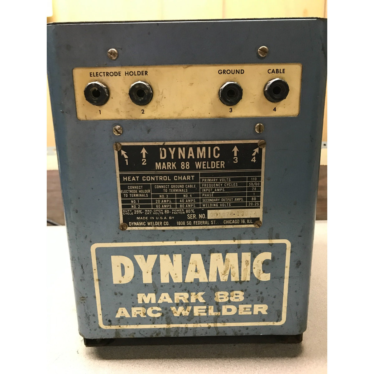 A vintage Dynamic Mark 88 Arc Welder machine with a blue-gray metal casing, beige control panel, and a prominent heat control chart label on the front.