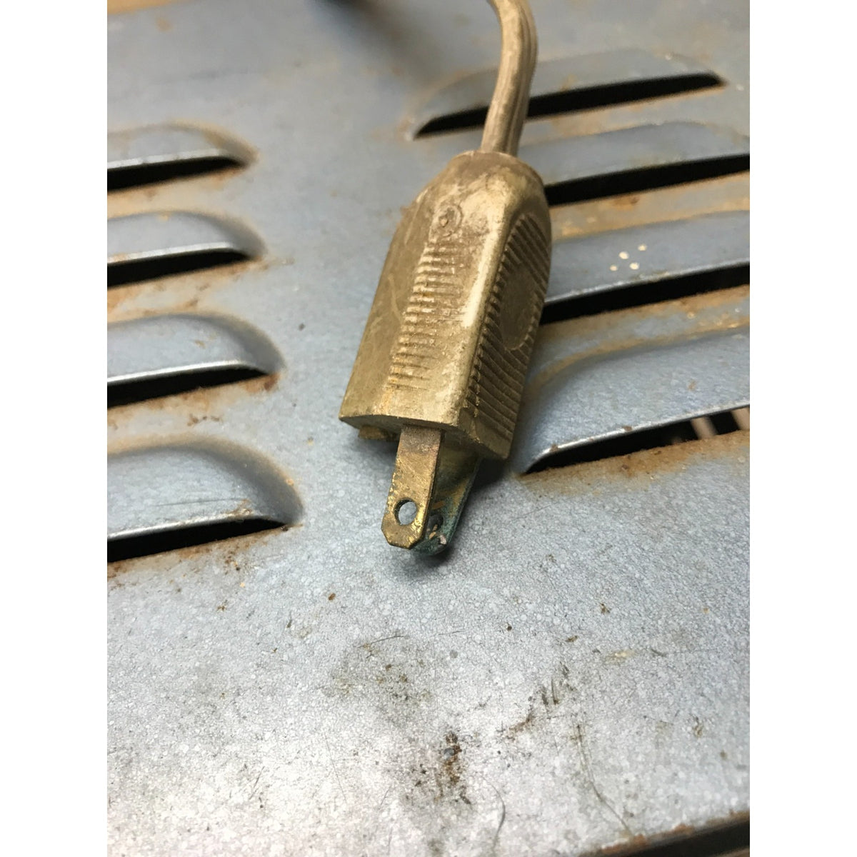 Dynamic Mark 88 Vintage Arc Welder 110V 28A electrical plug with a matching cord, resting on a weathered, rusty gray metal surface.