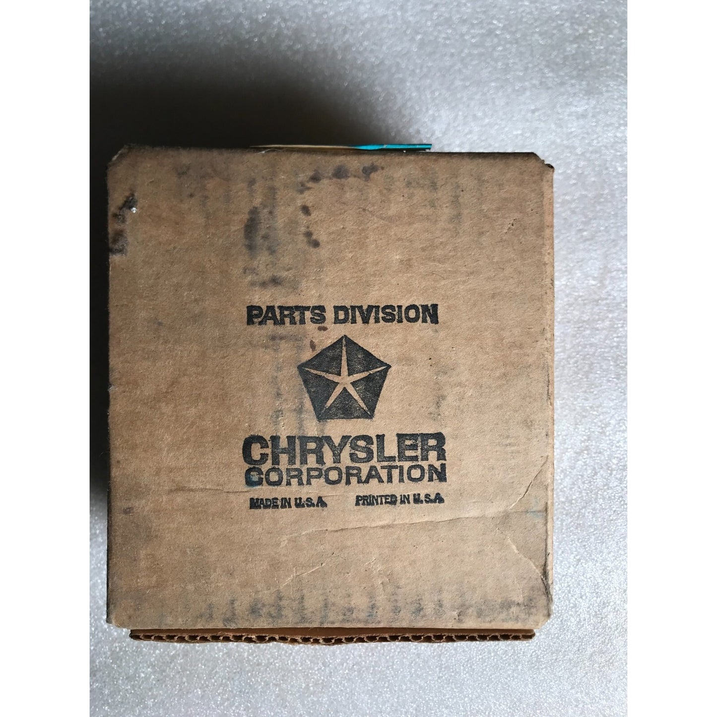 Vintage cardboard box with 'Chrysler Corporation' branding on a gray background