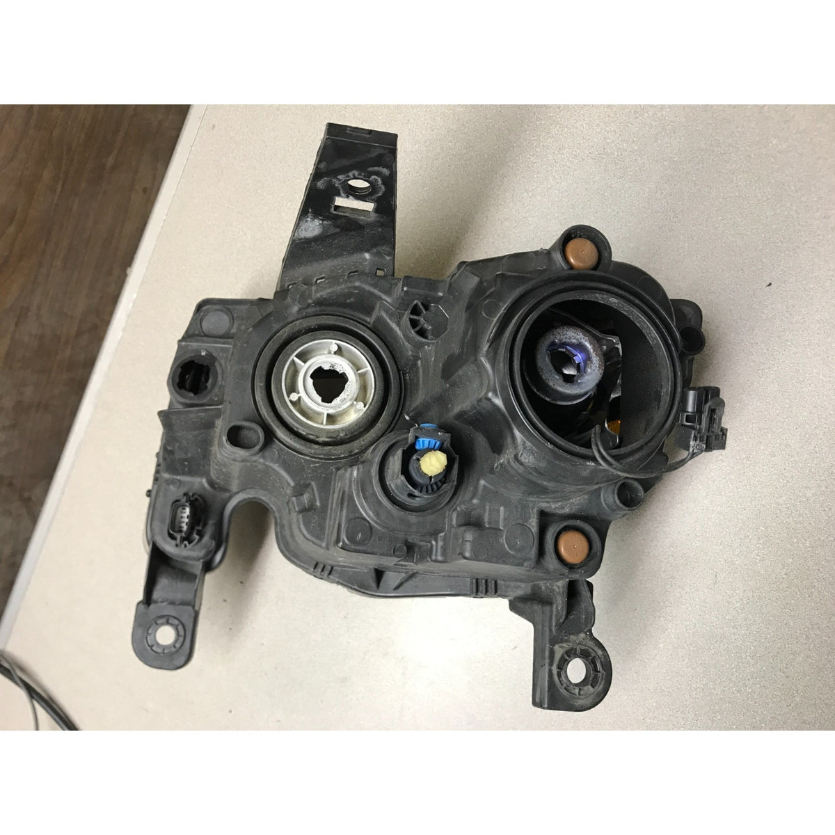 A used black plastic automotive part, likely a power window or door jammer assembly, photographed on a light beige surface. 2019 Jeep Grand Cherokee Altitude Front Right RH Valeo OEM Headlight Lens
