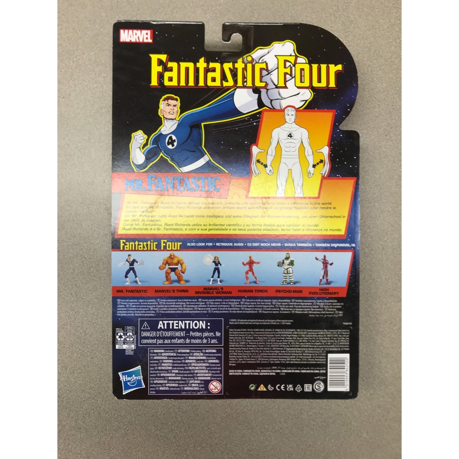 Back of a Marvel Fantastic Four action figure package on a neutral gray surface. The card features artwork of the characters, product details, and safety information, with Hasbro branding visible near the bottom.